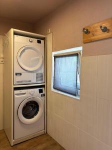 a laundry room with a washing machine and a window at Neubeginn 2 - Zimmer A in Hildburghausen