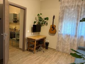 a room with a desk and a guitar on the wall at Domu de Ziu Peppino in Sìnnai