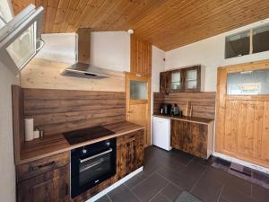 a kitchen with wooden cabinets and a stove at Neubeginn 2 - Zimmer A in Hildburghausen