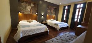 a hotel room with two beds and a couch at Hotel Inti by Okena in Quito