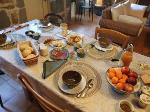 a table with plates of food and fruit on it at Le Coudi in Saint-Pierre-le-Chastel