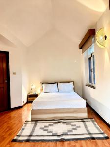 a bedroom with a bed and a rug on the floor at Winston's Speakeasy & Inn in Pātan