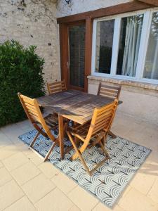 a wooden table and two chairs on a rug at Maison de campagne proche Giverny La Casita de Bemi in Bois-Jérôme-Saint-Ouen +3 photos