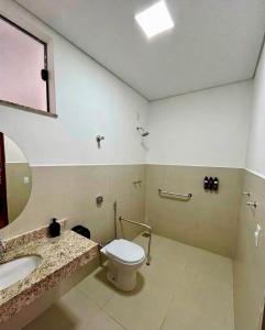 a bathroom with a toilet and a sink at Hotel Valadares in Alfenas
