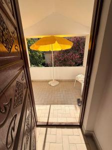 a yellow umbrella in a hallway with a table and chair at Central Nesst Budva in Budva