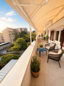 an outdoor balcony with chairs and a table at Central Nesst Budva in Budva