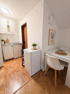 a living room with a table and a kitchen at Central Nesst Budva in Budva
