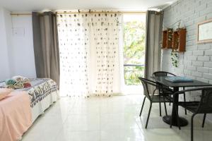 a bedroom with a bed and a table and a window at Sunset View, Taganga in Taganga +111 photos