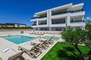 a villa with a swimming pool and lounge chairs at Villa Gaj 2 in Novalja