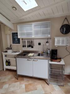 a kitchen with white cabinets and a sink at Maison de campagne proche Giverny La Casita de Bemi in Bois-Jérôme-Saint-Ouen