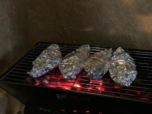 four pieces of food wrapped in tin foil on a grill at Nimansala Eco Resort in Parakaduwa