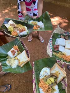 a group of plates of food on green leaves at Nimansala Eco Resort in Parakaduwa