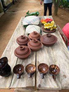 a wooden table with chocolate dishes and fruits on it at Nimansala Eco Resort in Parakaduwa