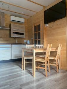 a dining room with a wooden table and chairs at Domki Letniskowe ARTEMI in Rowy +14 photos