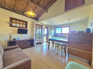 a living room with a couch and a table at Residencial Hibiscos - Vista Mar in Garopaba