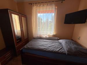 a small bedroom with a bed and a window at Kuźnia Międzylesie in Międzylesie