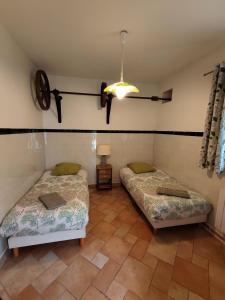a room with two beds and a table and a lamp at Maison de campagne proche Giverny La Casita de Bemi in Bois-Jérôme-Saint-Ouen