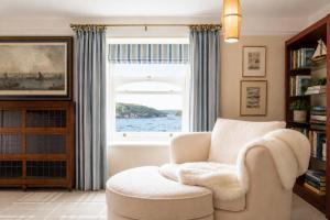 a living room with a chair and a window at Chy En Glas - By Rowes Retreats in Falmouth