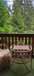 a table with two glasses of wine on a balcony at Chata v lese pri rieke Bela in Pribylina