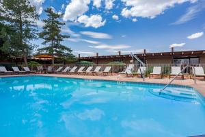 a large swimming pool with lounge chairs in front of a hotel at Kayenta Monument Valley Inn in Kayenta