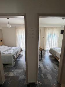 a room with two beds and a doorway to a bedroom at Hotel Angela in Asprovalta