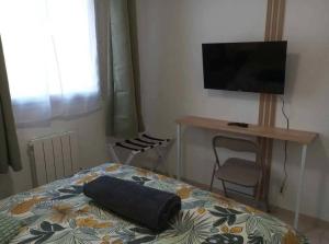 a bedroom with a bed with a flat screen tv at L'Etoile Biterroise - Location appartement de vacances - Béziers in Béziers