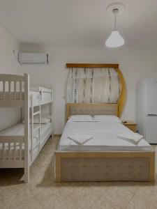 a bedroom with a bed and two bunk beds at Vila Vladmir Sela in Ksamil