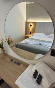 a bedroom with a bed and a mirror at Hotel Angela in Asprovalta