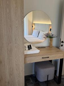 a bedroom with a bed and a desk with a mirror at Hotel Angela in Asprovalta +26 photos