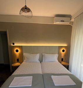 a bedroom with a bed with two white pillows at Hotel Angela in Asprovalta