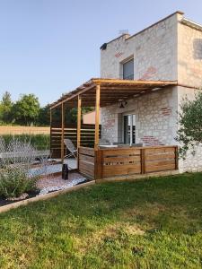 a house with a wooden deck in the yard at Pigeonnier de campagne in Moncaut