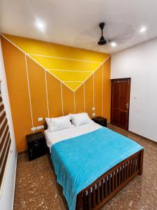 a bedroom with a large bed with a yellow wall at Private Pool Villa Vagamon in Vagamon
