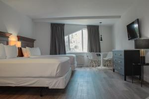 a hotel room with two beds and a table and a window at Hôtel Matha in Saint-Jean-de-Matha +68 photos