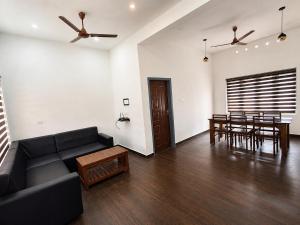 a living room with a couch and a dining room at Private Pool Villa Vagamon in Vagamon