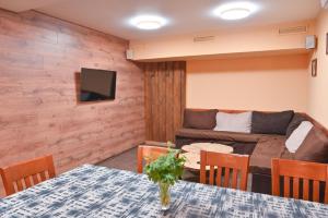 ein Wohnzimmer mit einem Tisch und einem Sofa in der Unterkunft Кирицова Къща in Bansko
