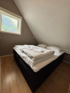 a bed in a attic room with a window at Undredal Fjord Apartments in Undredal +23 photos