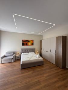 a white bedroom with a bed and a couch at Almare ApartHotel in Golem +56 photos