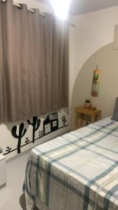 a bedroom with a bed and a window at Quarto Aconchego Nordestino in Aracaju