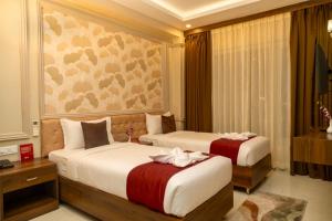 a hotel room with two beds with flowers on them at Odissey Suites in Bhubaneshwar +56 photos