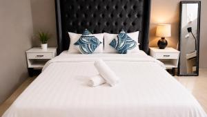 a bedroom with a large white bed with two pillows at Amazonite Maldives in Thulusdhoo