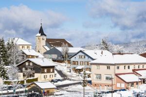 a town covered in snow with a church at Parenthèse nature à Prémanon in Prémanon