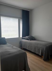 a bedroom with two beds and a window at The Cozy Corner in Turku