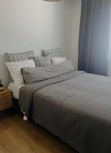 a bedroom with a large bed with gray sheets and pillows at The Cozy Corner in Turku