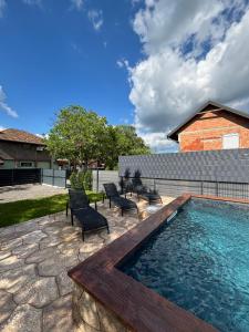 a backyard with a swimming pool and chairs and a house at Vila Luminis in Seone
