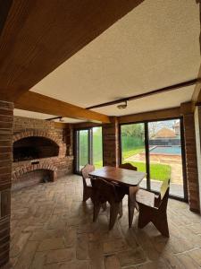 a living room with a wooden table and a brick fireplace at Vila Luminis in Seone
