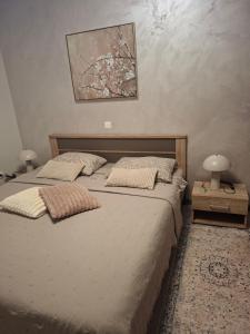 a bedroom with a bed with two lamps and a painting at Apartman IDEA in Rabac