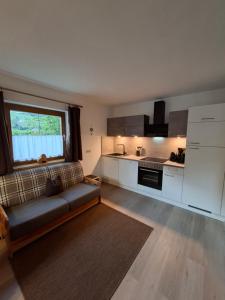 a living room with a couch and a kitchen at Haus Reiterer in Neustift im Stubaital