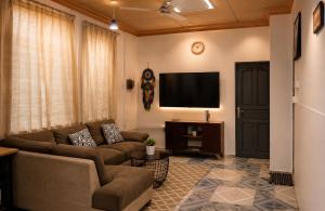 a living room with a couch and a flat screen tv at Amazonite Maldives in Thulusdhoo