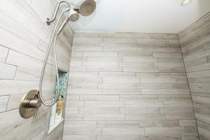 a shower in a bathroom with wooden tiles at Seaside Saloon Hot Tub Getaway in Sequim +18 photos