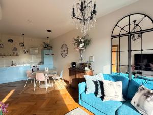 a living room with a blue couch and a kitchen at Old Town Fabulous view apartment in Tallinn